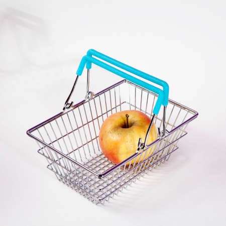 the Shopping basket with apple isolated on white backgroundの写真素材