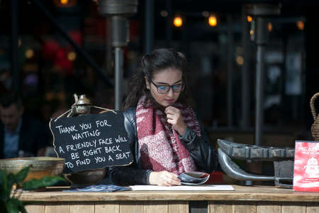 LONDON, ENGLAND - September 11, 2017 the restaurant manager reads the menu in anticipation of...