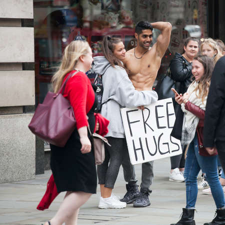LONDON, ENGLAND - September 11, 2017 Naked to the waist, a young man with a pumped up body holds a...