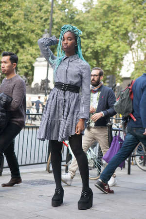 LONDON, ENGLAND - September 15, 2017 Beautiful and stylish girl with blue dreadlocks in a plaid dress and black pantyhose posing during the London Fashion Week.のeditorial素材