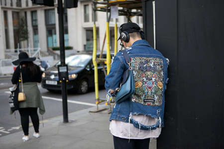 LONDON, ENGLAND - September 15, 2017 Beautiful and stylish Young man in a denim jacket. View from the back. posing during the London Fashion Week.のeditorial素材