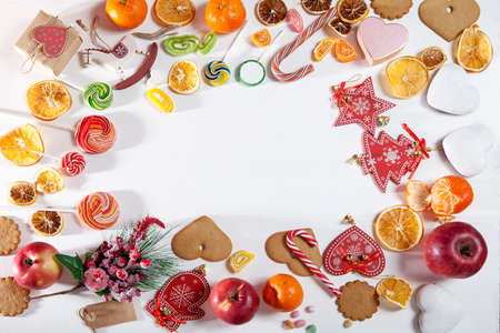Christmas backdrop with sweets, candies, toys, apples and tangerines. Copy spaceの写真素材