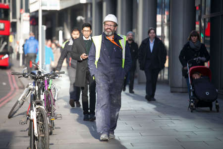 London, UK - December 22, 2017: Area near Liverpool street at noon in the backlight. A worker with...