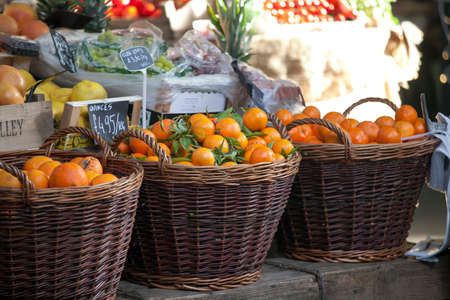 LONDON, ENGLAND - December 18 , 2017 Oranges in wicker baskets for sale on the Borough marketのeditorial素材