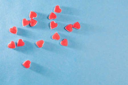Red hearts from chewing marmalade on a blue background