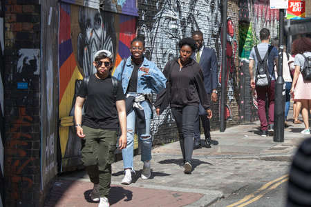 LONDON, ENGLAND - September 15, 2017 Young people walk along the sidewalk along Brick Lane Streetのeditorial素材