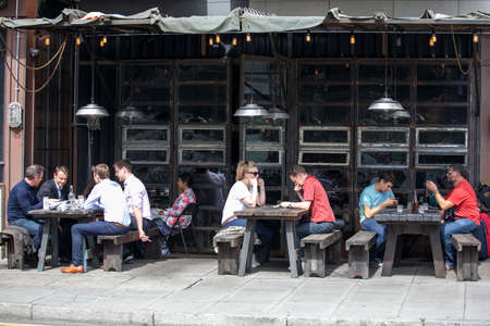 LONDON, ENGLAND - AUGUST 22, 2017 People eat lunch at a stylish street cafe in East London, near Brick Laneのeditorial素材