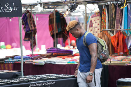 LONDON, ENGLAND - AUGUST 22, 2017 Buyers on the Spitalfelds market choose clothesのeditorial素材