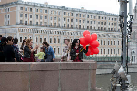 Moscow, Russia - 21 June 2017 A girl with red balloons posing on a bridge in the center of Moscowのeditorial素材