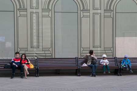 Moscow, Russia - 21 June 2017 A loving couple sitting on a bench in front of a house under constructionのeditorial素材