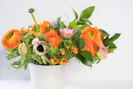 A wedding bouquet of buttercups, anemones and Ruscus on the white background