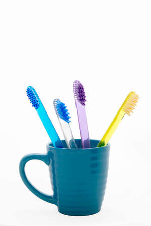 the four multi-colored toothbrushes in a blue glassの写真素材