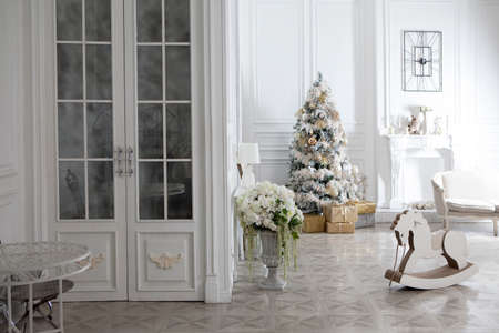 Toy wooden rocking horse in the New Year's interior. New Year's decorations. Decoration of the house. White wooden rocking horse. Christmas interiorの写真素材