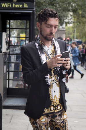 LONDON, UK- SEPTEMBER 14 2018: People on the street during the London Fashion Week. Brunette Curly young man in a shirt from Armaniのeditorial素材
