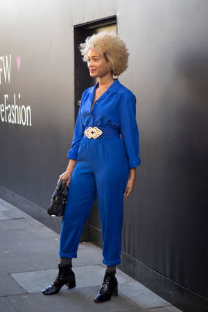 LONDON, UK- SEPTEMBER 14 2018: People on the street during the London Fashion Week. Curly blonde girl in blue jumpsuit smilingのeditorial素材