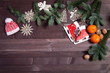 Branches of a Christmas tree with dry oranges and New Year's toys on wooden background. Christmas...