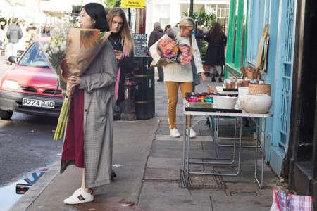 LONDON, ENGLAND - October 12, 2018 People buying flowers at Columbia Road Flower Market. This London's principal flower market is opened every Sunday.のeditorial素材