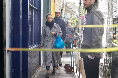 LONDON, ENGLAND - October 12, 2018 People buying flowers at Columbia Road Flower Market. This...