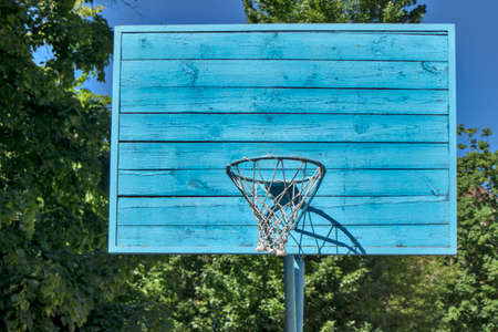 Blue wooden basketball backboard in the park among the linden treesの写真素材