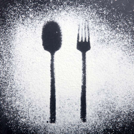 Spoon and fork silhouette made with flour on dark texture backgroundの写真素材