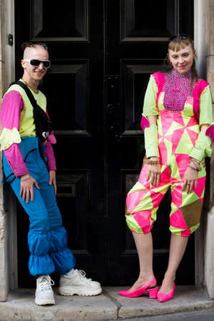 LONDON, ENGLAND - September 15, 2019 Stylish attendees gathering outside 180 Strand for London Fashion Week. Couple dressed in funny colorful party in neon colors.のeditorial素材