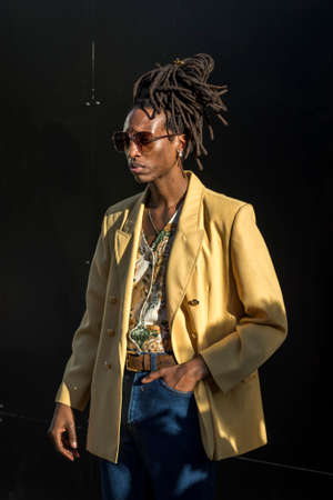 LONDON, ENGLAND - September 15, 2019 Stylish attendees gathering outside 180 Strand for London Fashion Week. Young man with dreadlocks in a yellow jacketのeditorial素材