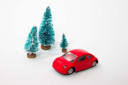 the Red toy car with a christmas tree on the roof, white background, shallow depth of field.