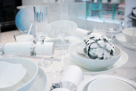 Christmas festive table decoration in white colors. Painted white artichoke in a ceramic plateのeditorial素材
