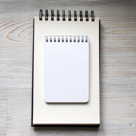 two white notebooks for writing different shapes lie on the tableの写真素材