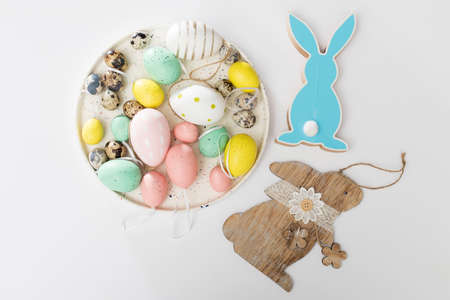 Quail eggs on a white dish. decoration. Packing canvas gift bags with buttons in the form of a hare on a white background. Easter card. Copy spaceの写真素材