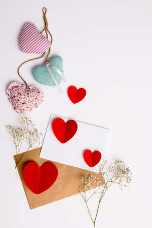 Greeting card for Valentine's Day. Envelopes on a white background and red plastic hearts. Copy...