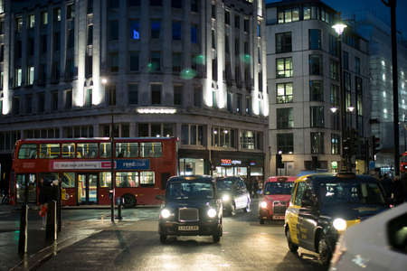 LONDON, UK- febryary 15 2020: London nightlife. Reflections on wet pavement from taxis and buses....