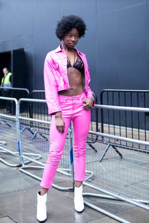 LONDON, UK- febryary 15 2020: Fashionable people on the street . Street style. Girl with a curly...