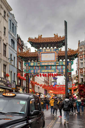 LONDON, UK - March 20, 2020: Chinatown with unidentified people on a rainy day. Chinatown is part of the Soho area with a range of Chinese restaurants and other Chinese run businesses.のeditorial素材