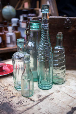 London, UK - 13 February, 2020 Spitalfields flea market. Glass bottles of different shapes on a wooden tableのeditorial素材