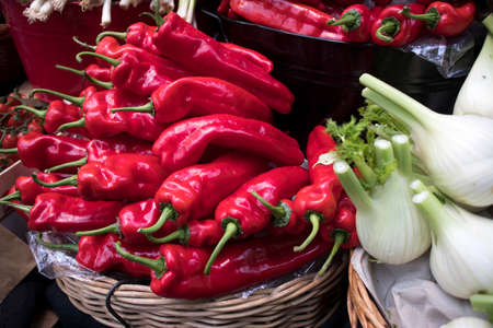 Red peppers falling out of a wicker basket as a decoration of the vegetable department