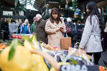 London, UK - 12 March 2020 Selling vegetables at Borough Market . Girls buy vegetablesのeditorial素材