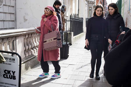 London, UK - 15 January, 2020, Fashionable people on the street. Street style. Young woman in black...