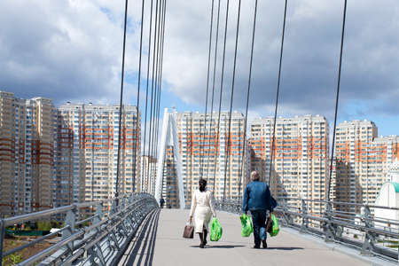 MOSCOW, RUSSIA - May 16, 2020: Construction of Moscow river embankment and St. Nicholas Church in new area of Pavshinsky floodplain. People go on Pavshinsky pedestrian bridge across the Moskva riverのeditorial素材