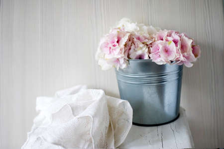 Pink hydrangea flower on a white stool and lace fabric. Copy spaceの写真素材
