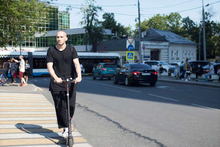 Moscow, Russia - 26.06.2020, The film director, Kirill Serebrennikov, was convicted of embezzling government grant. A man in a black T-shirt rides a scooter at a pedestrian crossingのeditorial素材