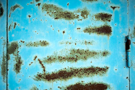 Texture of a metal wall with cracks and scratches which can be used as a background. Blue with rust....