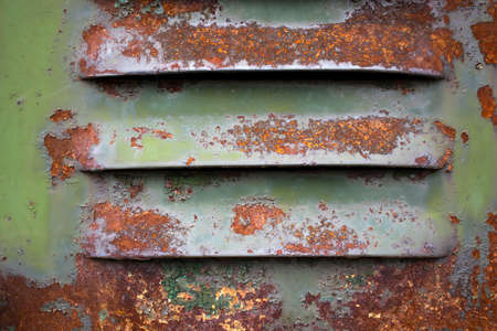 Texture of a metal wall with cracks and scratches which can be used as a background. The structure of the metal grid from an old battery. Pattern. Green color with rustの写真素材