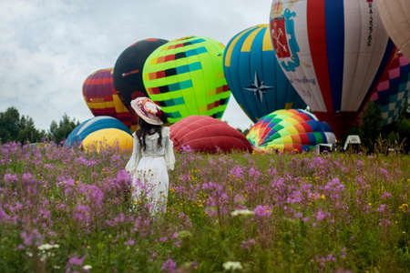 Pereslavl-Zalessky, Yaroslavl Region, Russia, - July 19, 2020: 19 - Aeronautics Festival Golden Ring. Girl dressed in vintage dress and hat posing against the background of balloons.のeditorial素材