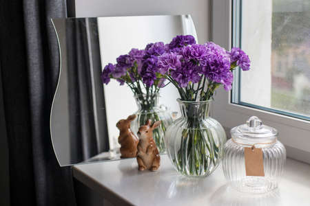 Bridal bouquets of lilac carnations in a round glass vase different sizes as table decorationの写真素材