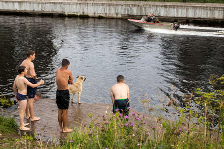 BELOZERSK, RUSSIA - 03 August 2020, Embankment in the city of Belozersk. Vologda Region. Boys swim in a canal near the lakeのeditorial素材