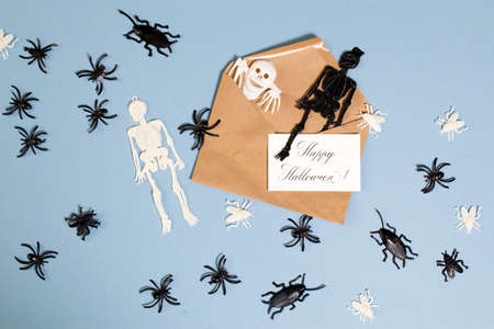 Calligraphic inscription Happy Halloween on white textured paper, on brown envelope, blue paper...