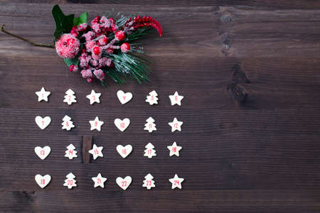 Figures for days of December, Christmas advent on brown wooden background. Figures for days of...
