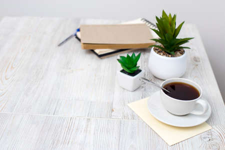 desk office with blank notepad, coffee cup and pen on wood table. Flat lay top view copy space.の写真素材