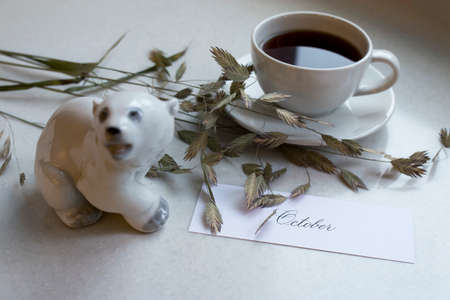 A white cup of tea is on the windowsill. Nearby is a figurine of a polar bear, dried cerealsの写真素材